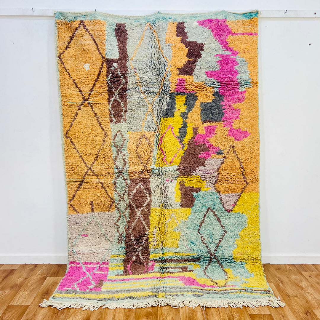 Vintage Moroccan rug in pastel colors, showcasing diamond motifs and vibrant hues like pink, yellow, and mint green. 235 x 156 cm.