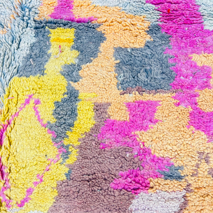 Vibrant vintage Moroccan rug with asymmetrical pastel patterns and diamond motifs, features pink, honey mustard, and mint hues.