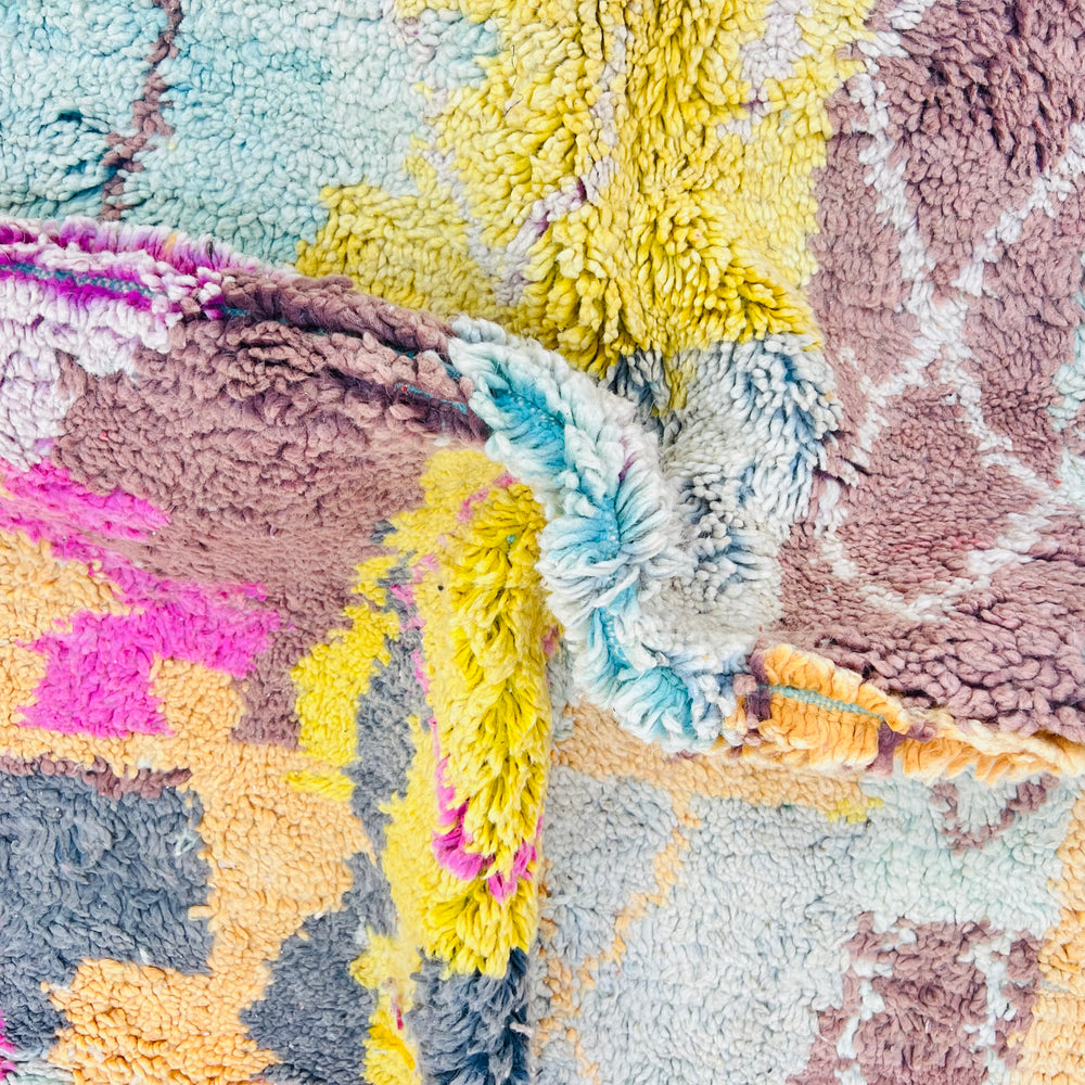 Vintage Moroccan rug with pastel colors including honey mustard, pink, and mint, showcasing bold Berber diamond patterns.