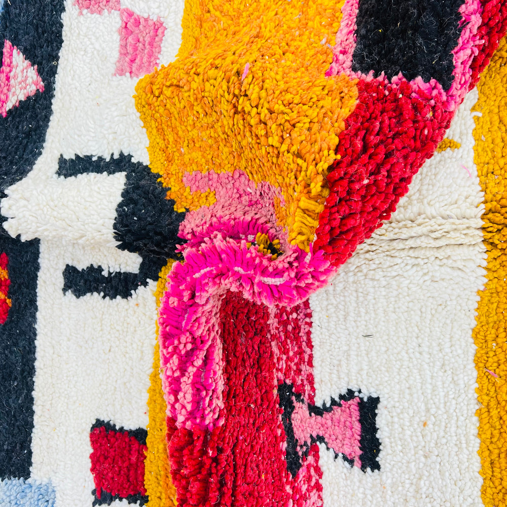 Vintage Moroccan Berber shag rug with vibrant red, pink, orange, and blue abstract tribal patterns, handwoven wool texture.