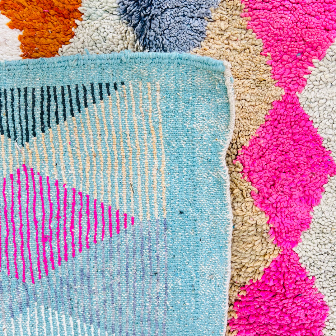 Vintage Moroccan rug with diamond pattern in pink, terracotta, beige, turquoise, and blue. Hand-knotted wool by Berber artisans.
