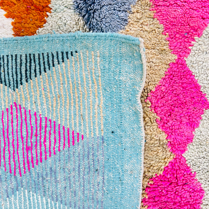 Vintage Moroccan rug with diamond pattern in pink, terracotta, beige, turquoise, and blue. Hand-knotted wool by Berber artisans.