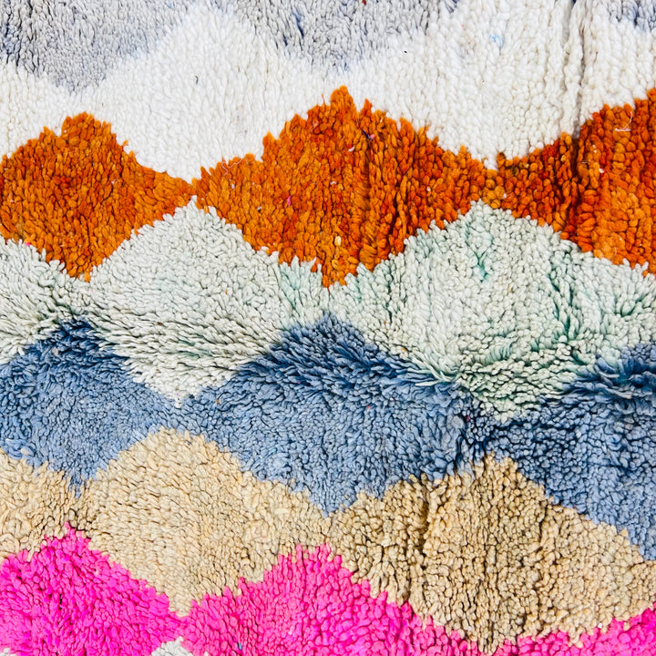 Vintage Moroccan wool rug with diamond pattern in pink, terracotta, charcoal, beige, and turquoise. Hand-knotted by Berber artisans.