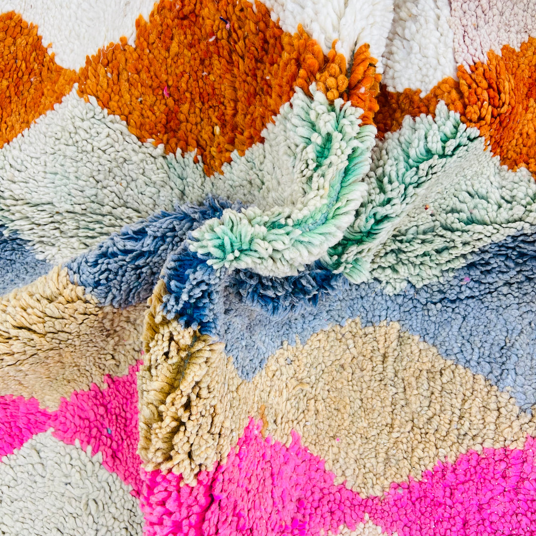 Close-up of vintage Moroccan wool rug with bold diamond pattern in pink, terracotta, charcoal, beige, turquoise, and blue. Rug 471.