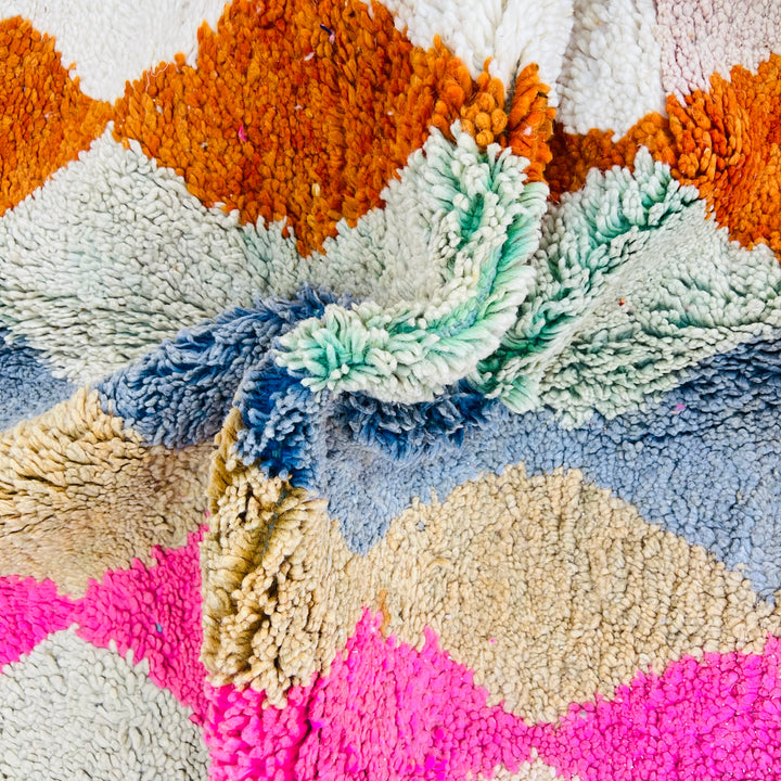Close-up of vintage Moroccan wool rug with bold diamond pattern in pink, terracotta, charcoal, beige, turquoise, and blue. Rug 471.