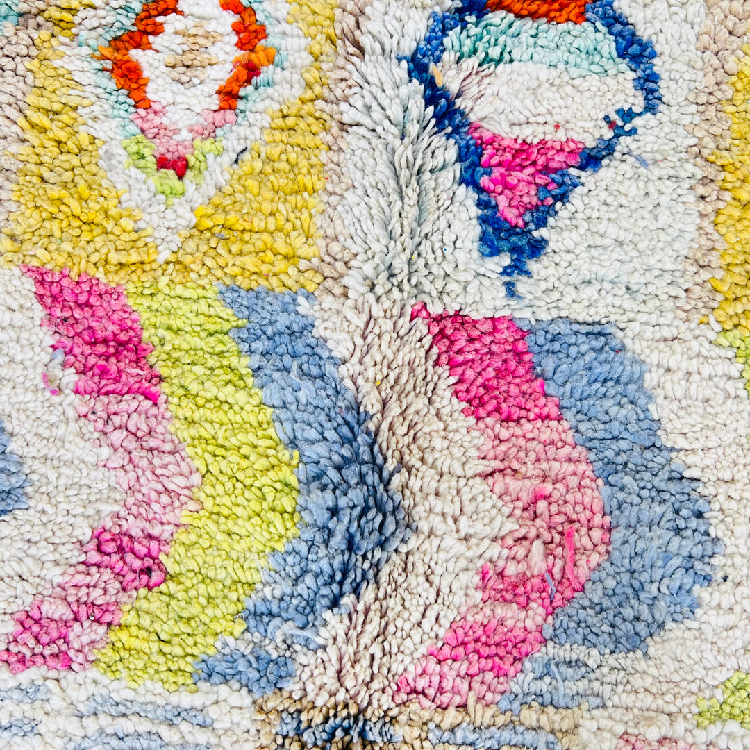 Close-up of vintage Moroccan Berber rug with multicolor tribal motifs and textures, crafted from 100% wool.