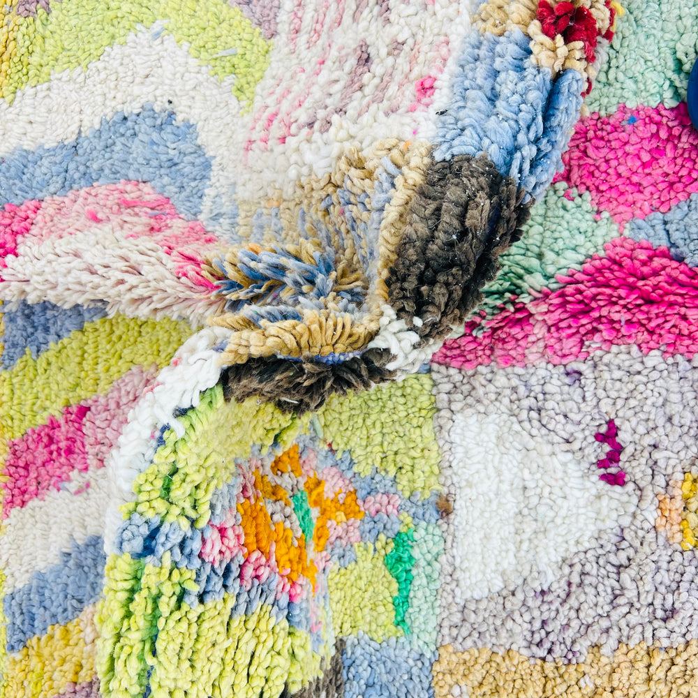 Close-up of a vibrant vintage Moroccan Berber rug with multicolored tribal motifs and textures, crafted from 100% wool.