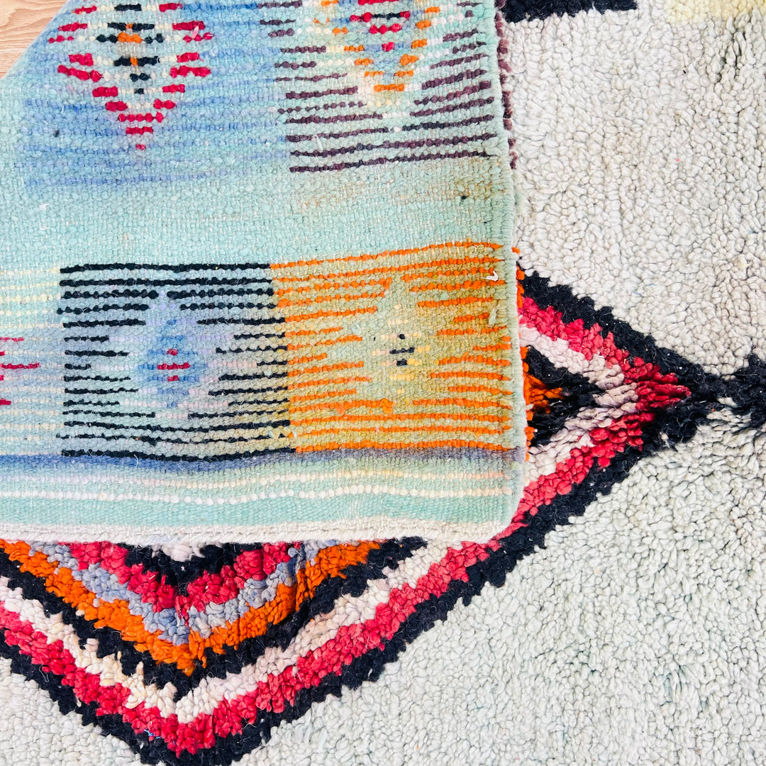 Vintage Moroccan rug with diamond motif, vibrant geometric patterns, deep red, orange, black, and cream tones, handmade by Berber artisans.