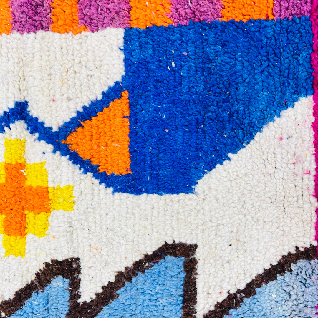 Close-up of abstract vintage Moroccan rug with geometric motifs in vibrant colors, showcasing traditional Moroccan wool craftsmanship.