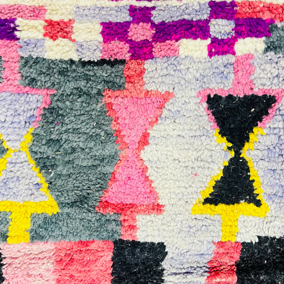 Colorful vintage Moroccan rug with geometric patterns in pink, yellow, blue, and black, showcasing Berber artistry. Perfect as area rug.
