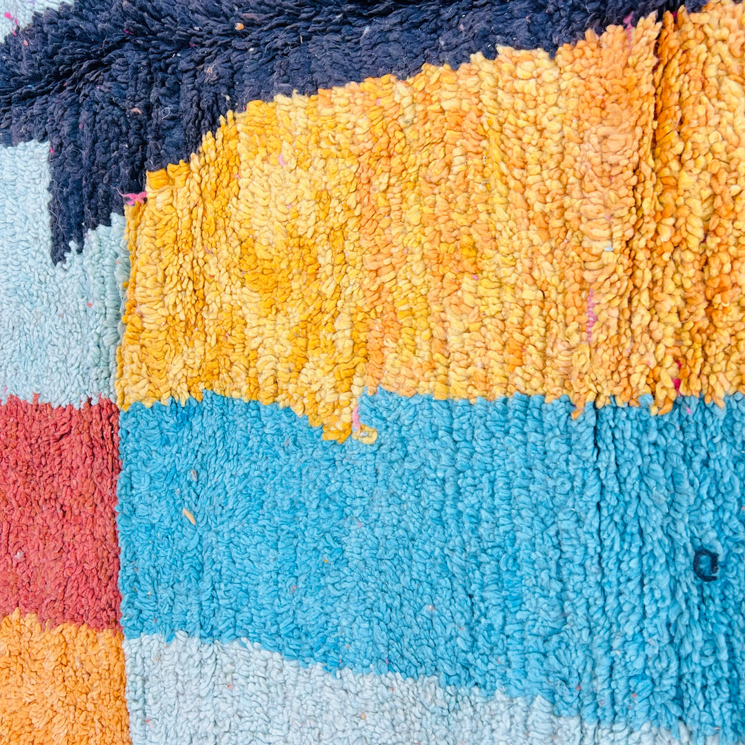 Colorful vintage Moroccan berber rug with bold stripes in orange, pink, turquoise, and yellow. Handwoven abstract design.