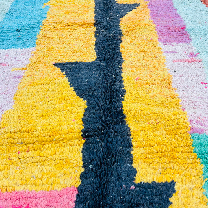 Colorful abstract Moroccan rug with bold stripes and central black pattern, featuring orange, pink, and turquoise accents. Handwoven wool rug.
