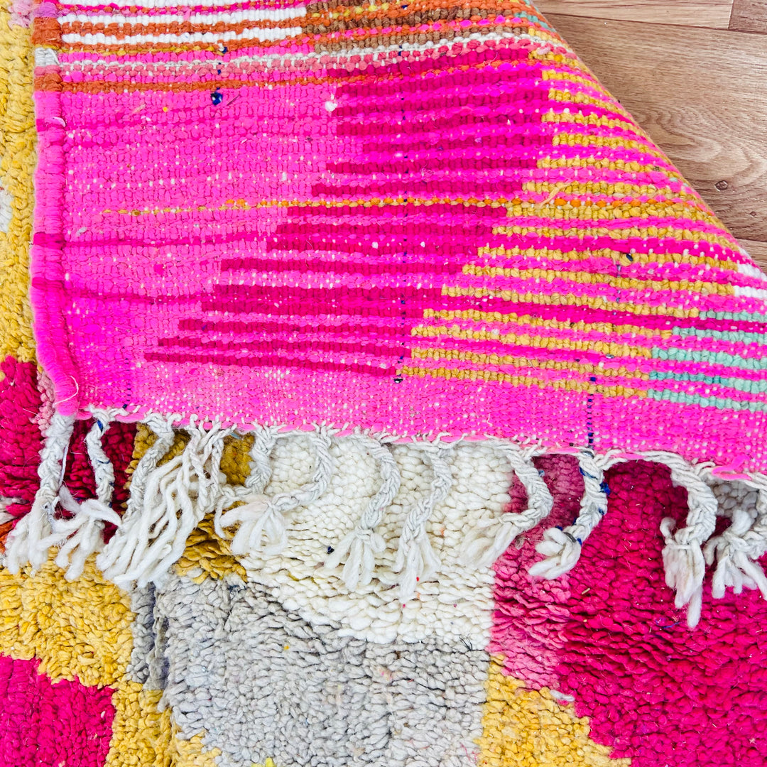 Colorful vintage Moroccan Berber rug with pink and yellow stripes, traditional handwoven wool carpet.