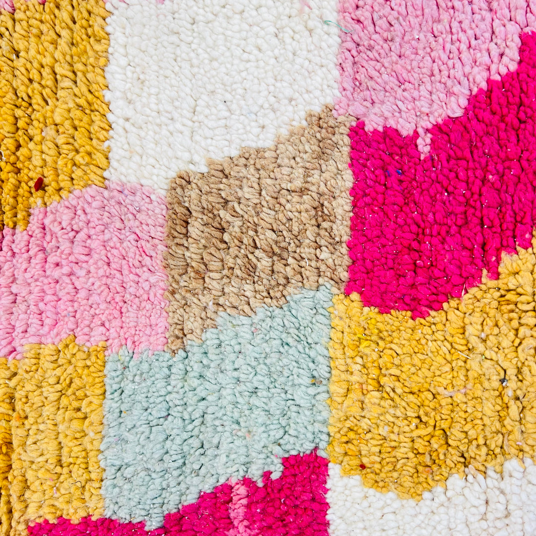 Colorful vintage Moroccan Berber rug with pink, yellow, and pastel tones, showcasing traditional handwoven patterns.