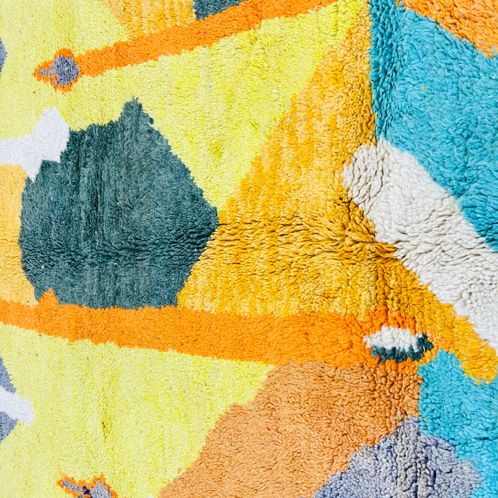 Vintage Moroccan rug with abstract geometric patterns in turquoise, yellow, orange, and green. Handmade Berber design.