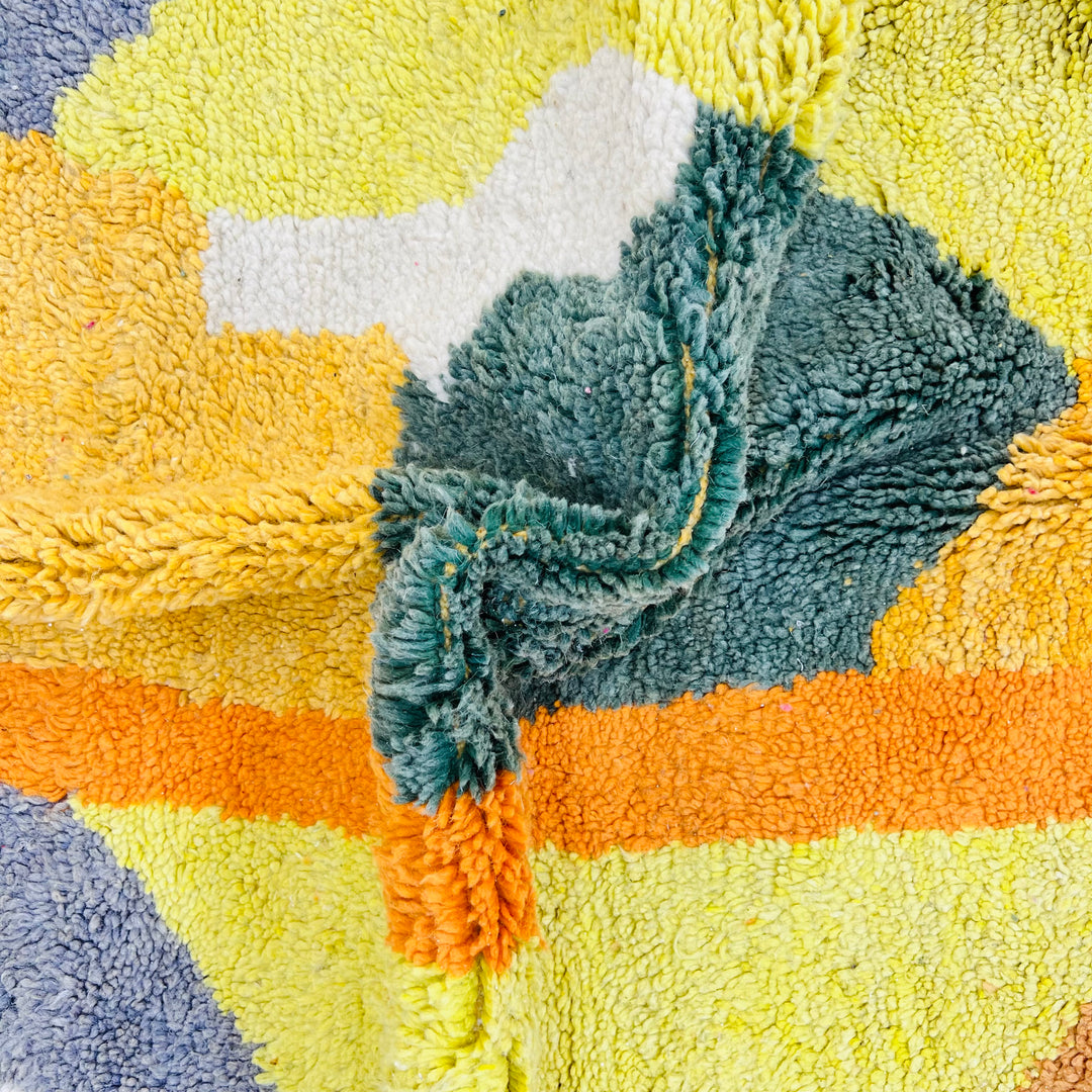 Abstract Moroccan rug with turquoise, mustard, green, and orange geometric pattern, vintage Berber style, handmade wool texture.