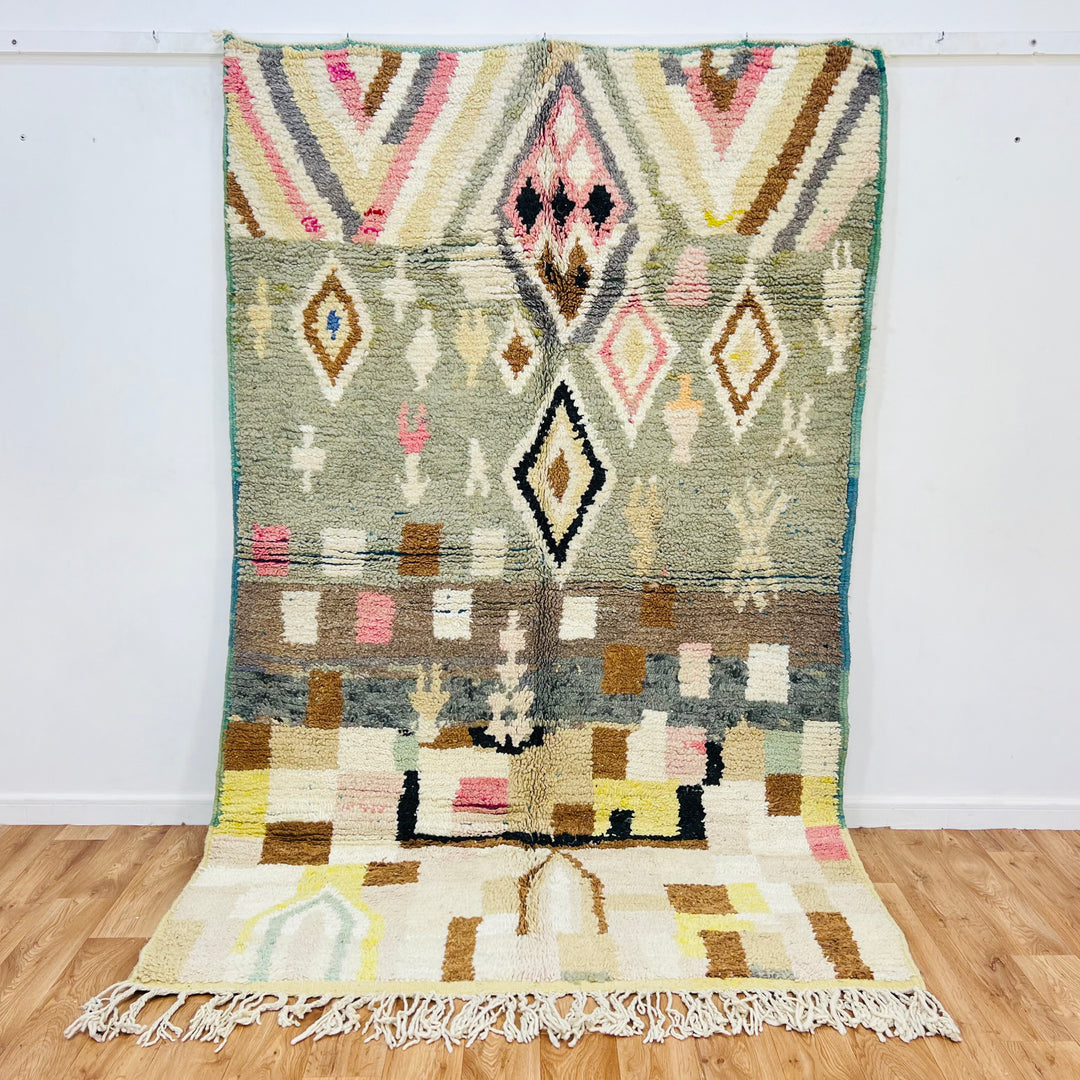 Vintage Moroccan Berber wool rug with geometric patterns in olive, pink, mustard, and ivory. Handcrafted by artisans. 8.46 x 5.05 ft.