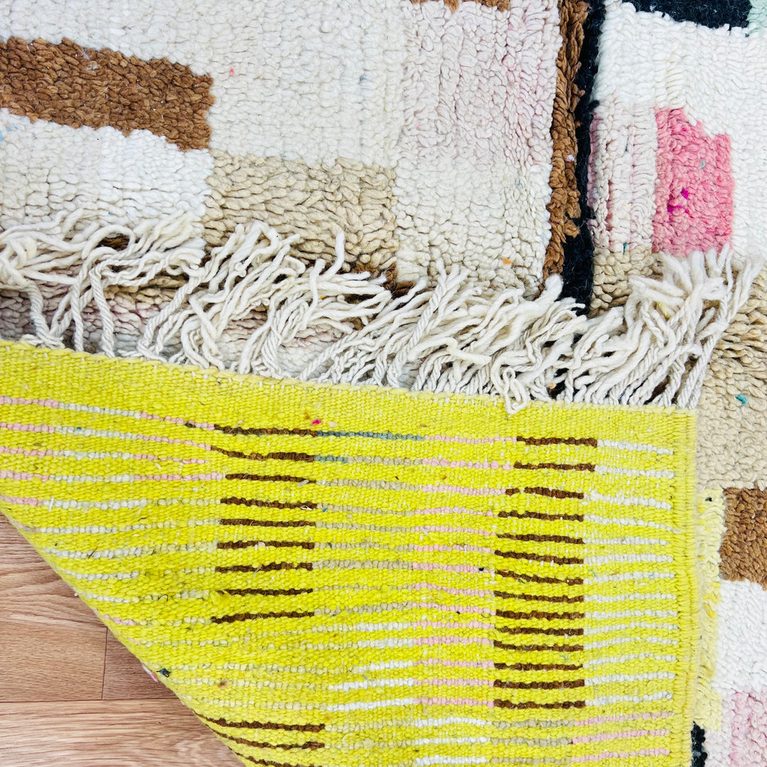 Vintage Moroccan rug with geometric patterns in olive green and pink, showcasing Berber craftsmanship and abstract tribal designs.