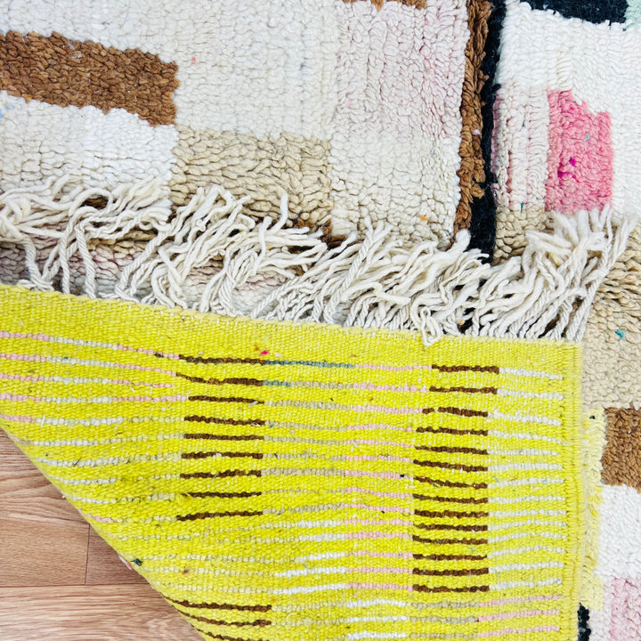 Vintage Moroccan rug with geometric patterns in olive green and pink, showcasing Berber craftsmanship and abstract tribal designs.