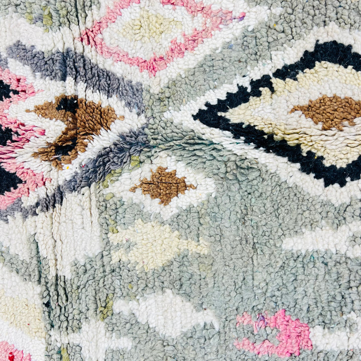 Vintage Moroccan rug with abstract tribal symbols and geometric diamond patterns in olive, pink, mustard, and ivory colors.
