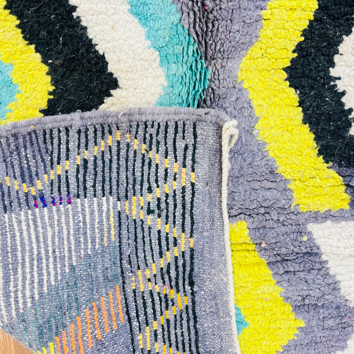 Chevron Moroccan Berber wool rug with vibrant zigzag patterns in yellow, turquoise, grey, black, and cream. Handmade tribal artwork.