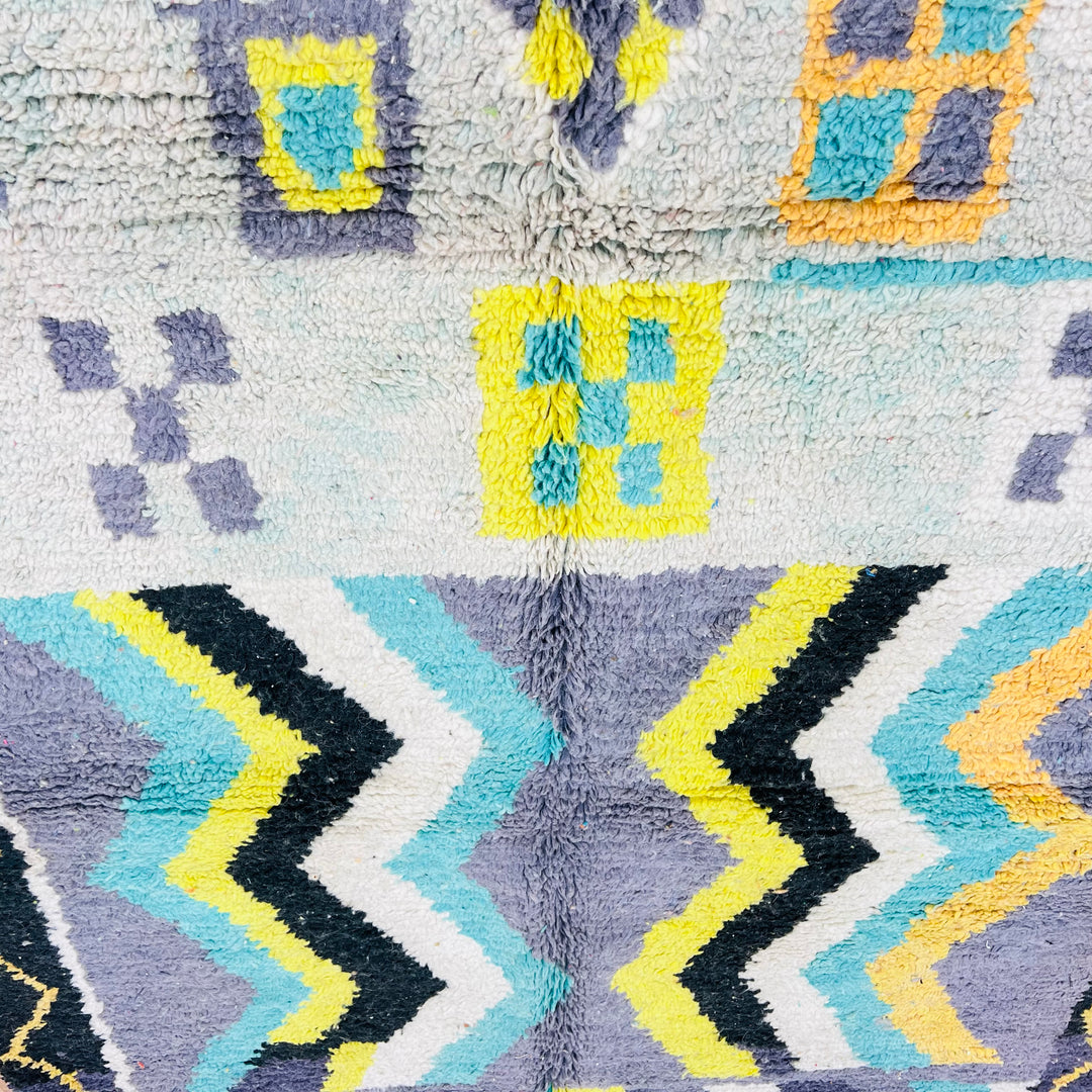Vintage Moroccan rug with chevron patterns in yellow, turquoise, and black. Handcrafted Berber wool rug featuring symbolic motifs.