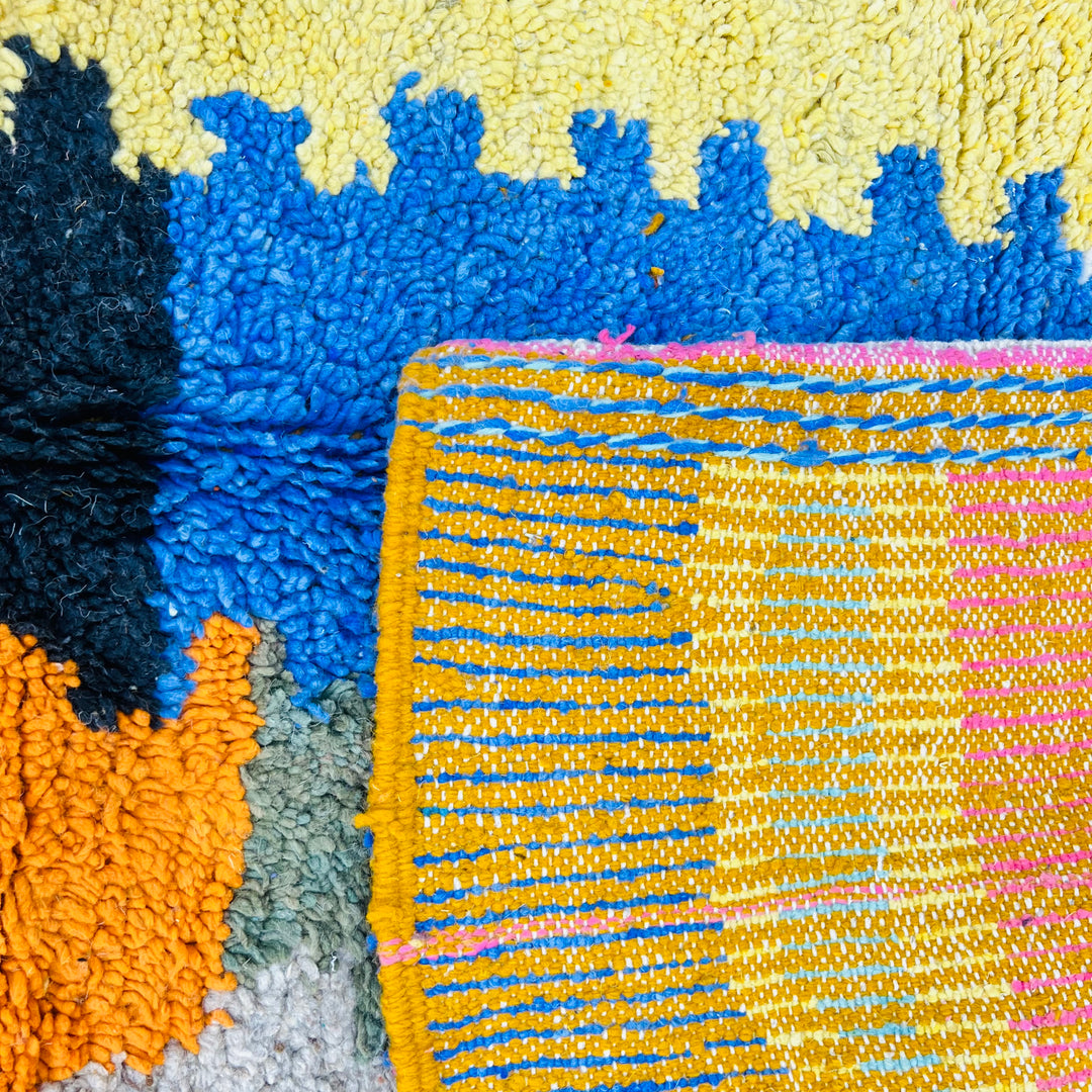 Colorful vintage Moroccan rug with abstract lines and bold colors, handmade Berber design in pink, orange, blue, and yellow.