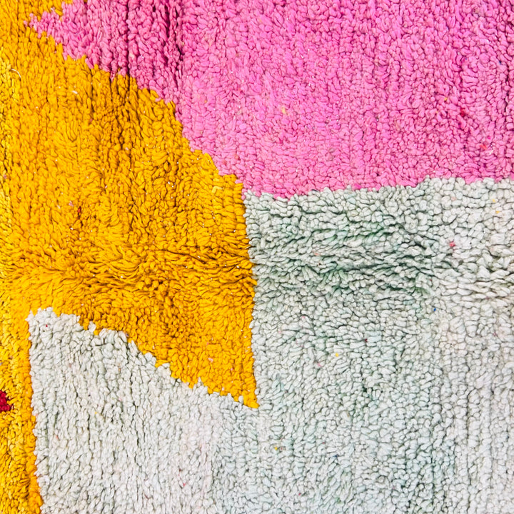 Bold abstract vintage Moroccan Berber rug with pink, yellow, and sage blocks, handmade wool, 8.3x5.2 ft, artistic interiors.