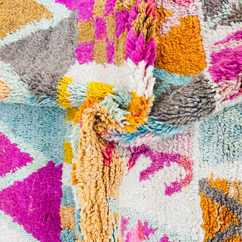 Colorful vintage Moroccan rug with pink, turquoise, and orange geometric patterns, handmade by Berber artisans.