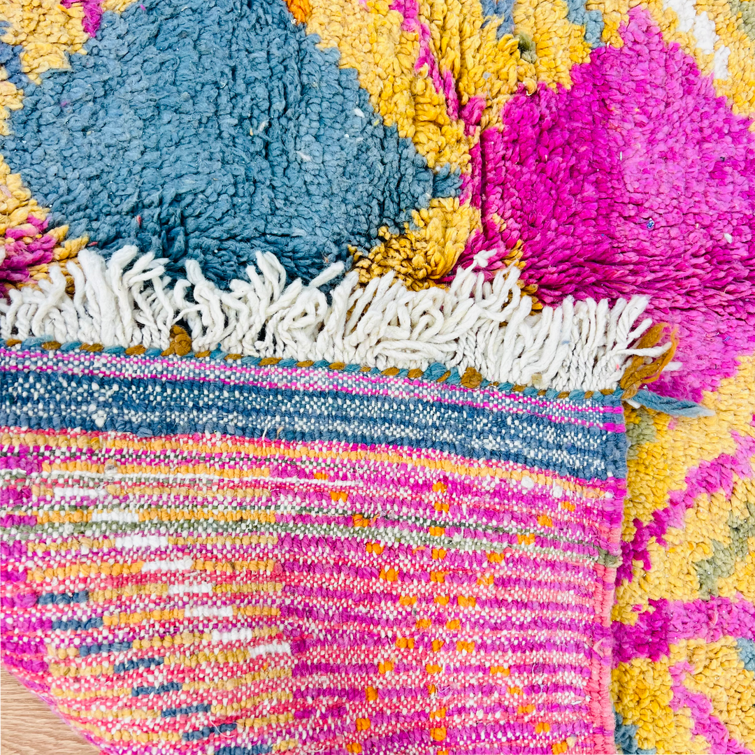 Colorful vintage Moroccan wool rug with pink, teal, ochre patterns, showcasing traditional Berber design and lush texture.