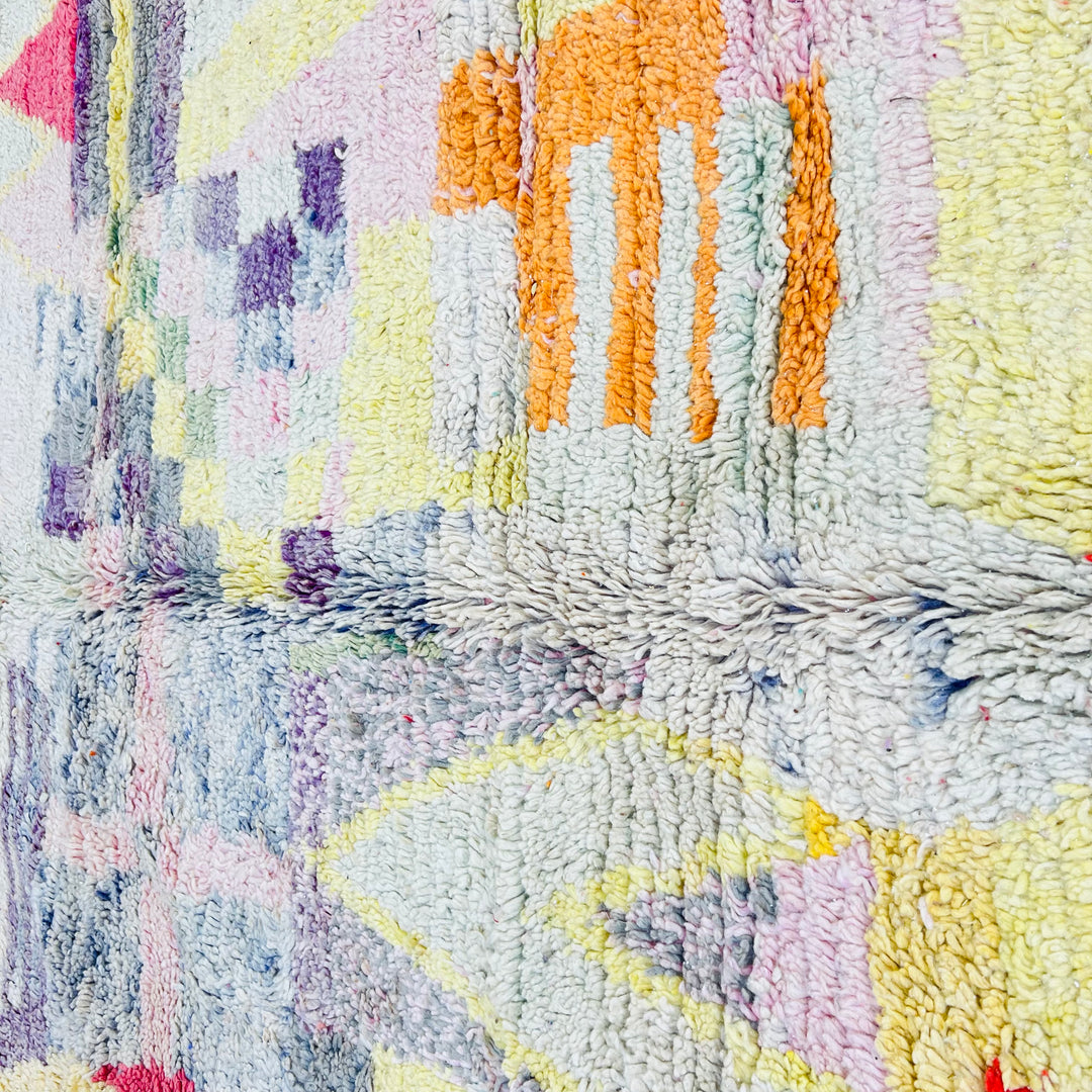 Vintage Moroccan rug with vibrant abstract designs in purple, yellow, pink, and red, showcasing Berber craftsmanship.