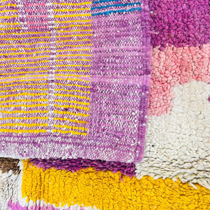 Vibrant vintage Moroccan wool rug with colorful geometric patterns, handwoven by Berber artisans; perfect for boho interiors.