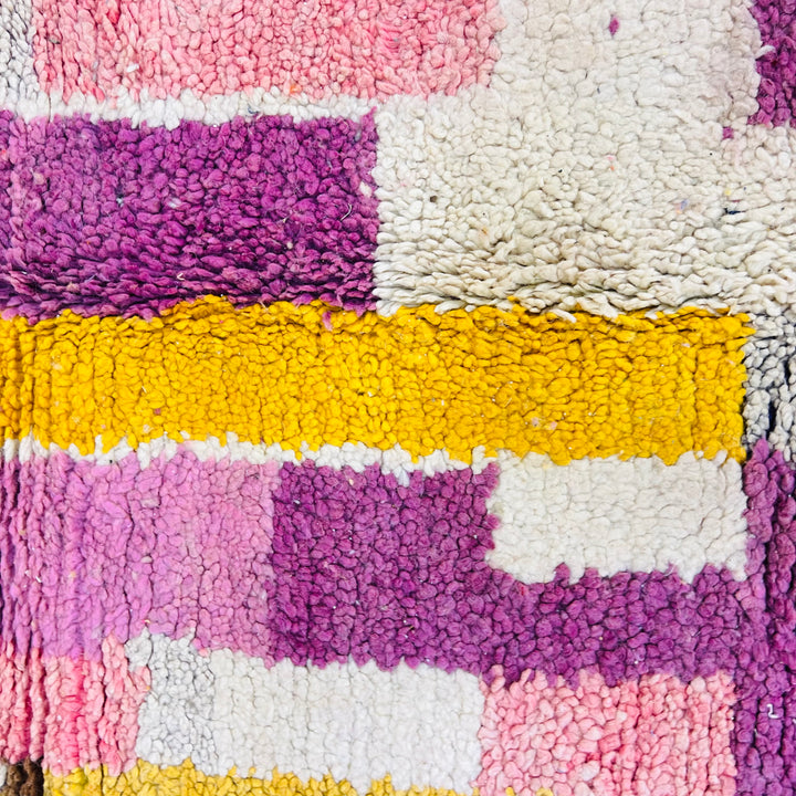 Colorful vintage Moroccan wool rug with geometric blocks in pink, purple, yellow, and white. Handwoven Berber craftsmanship.