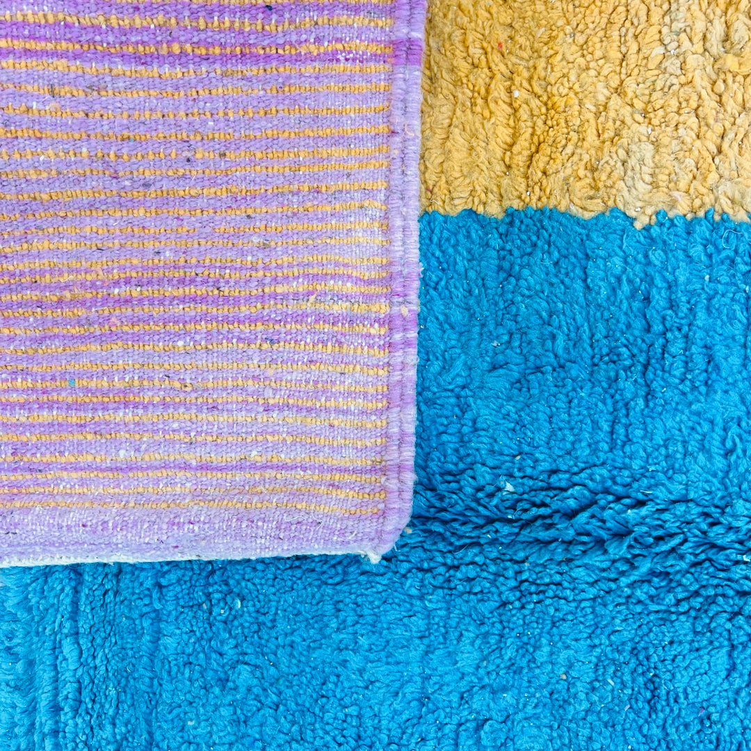 Modern Moroccan wool rug with mustard, turquoise, and pink color block design, showcasing Berber craftsmanship. Area rug 8.3 x 5.3 ft.