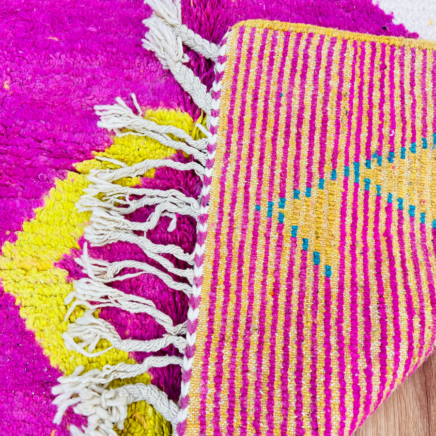 Bold pink Moroccan Berber rug with vibrant geometric patterns and fringed edges, perfect as an area or wool rug from Morocco.