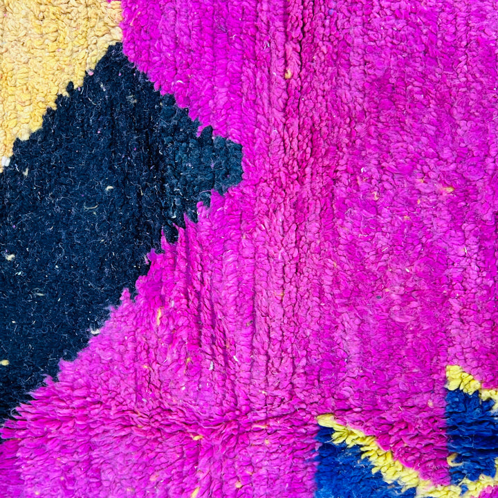 Bold pink Moroccan Berber rug with vibrant geometric patterns in magenta, yellow, blue, and black. Handmade vintage wool rug.