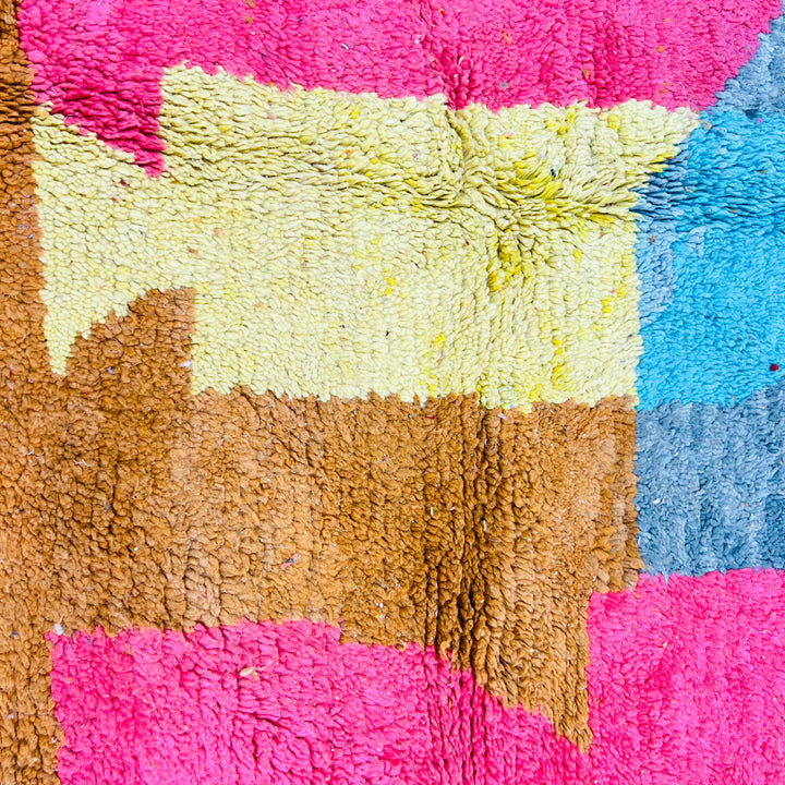 Colorful abstract Moroccan rug with pink, yellow, brown, and blue geometric patterns. Vintage Moroccan Berber craftsmanship.