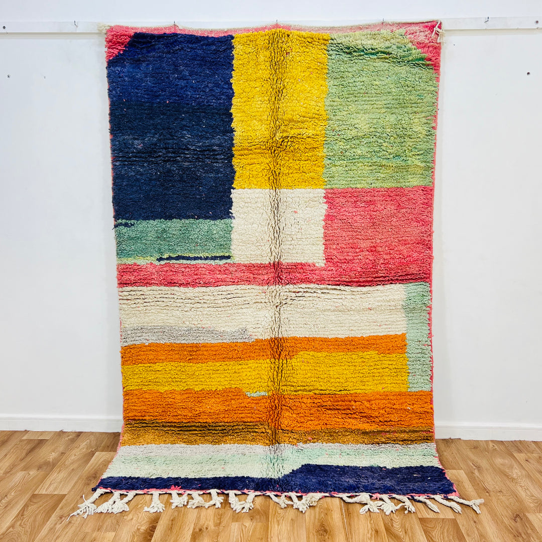 Handmade Moroccan wool rug with colorful patchwork design in navy, yellow, green, red, orange, and ivory, 233x153 cm.