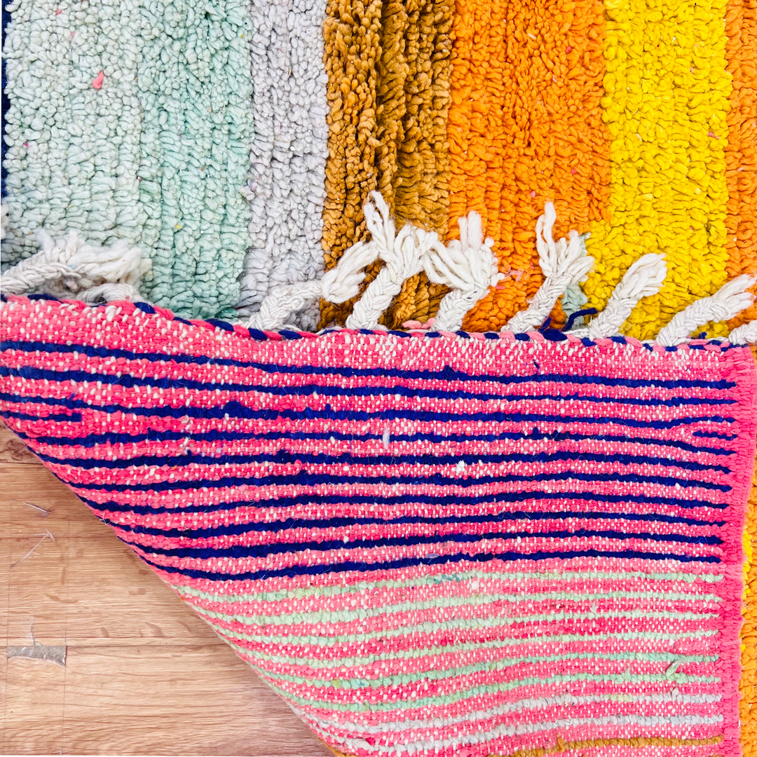 Colorful handmade Moroccan wool rug with vibrant stripes and fringes, perfect for eclectic interiors. Vintage design.