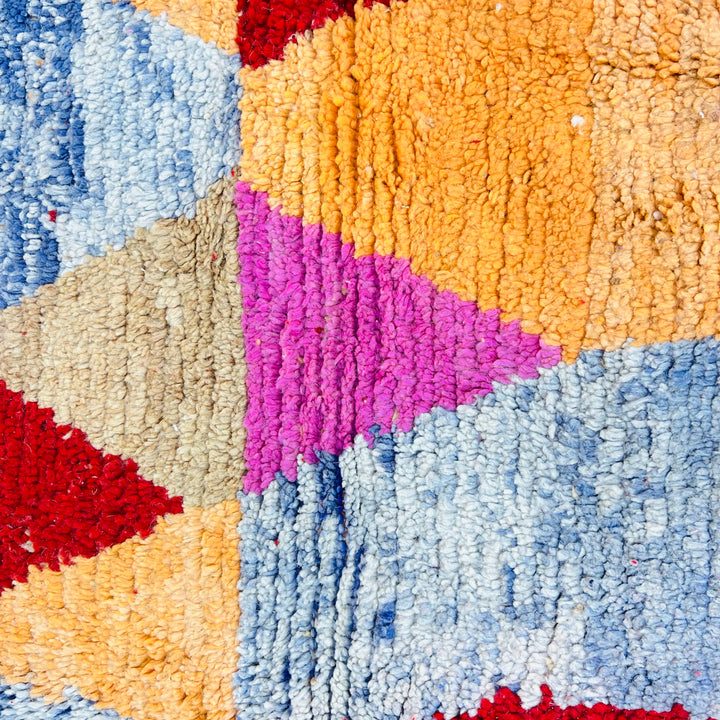 Vintage Moroccan rug with colorful diamond harlequin pattern in red, coral, ochre, pink, beige, and slate blue. Handmade wool carpet.