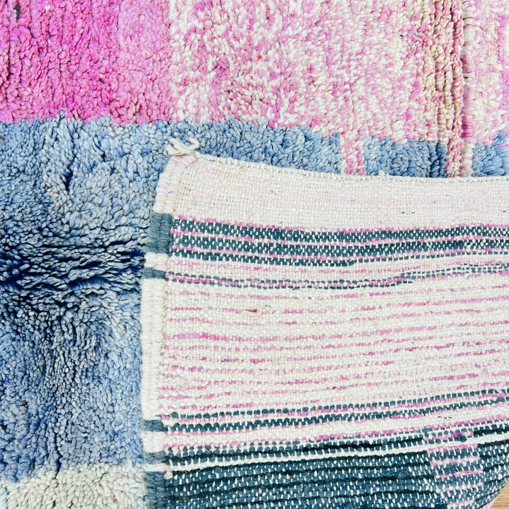 Vintage Moroccan wool rug in pink, blue, and cream, showcasing traditional Berber weaving patterns, perfect for home decor.
