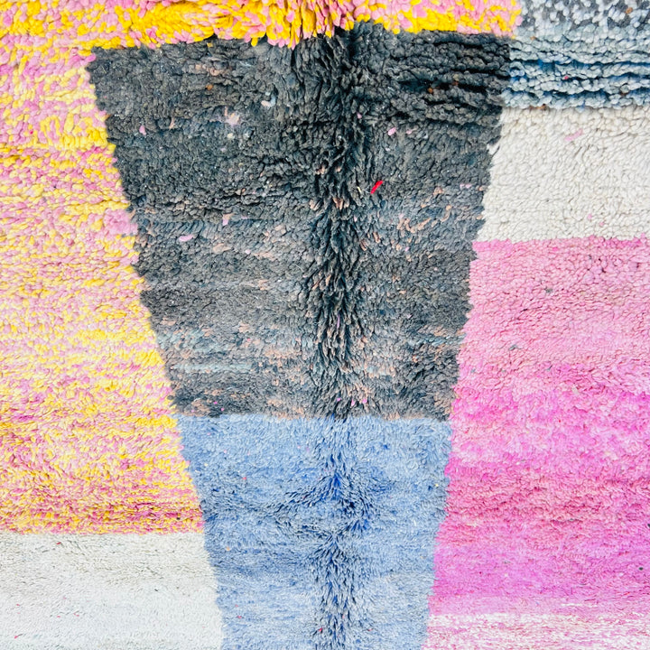 Vintage Moroccan wool rug featuring pink, blue, black, and cream blocks; handcrafted with traditional Berber techniques.