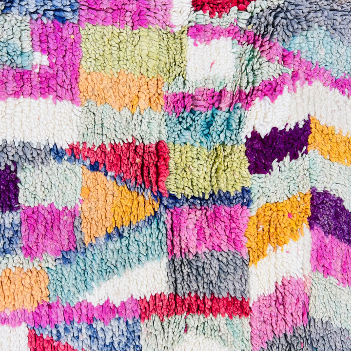Colorful vintage Moroccan rug with geometric motifs in vibrant red, lilac, teal, yellow, and orange by Berber artisans.