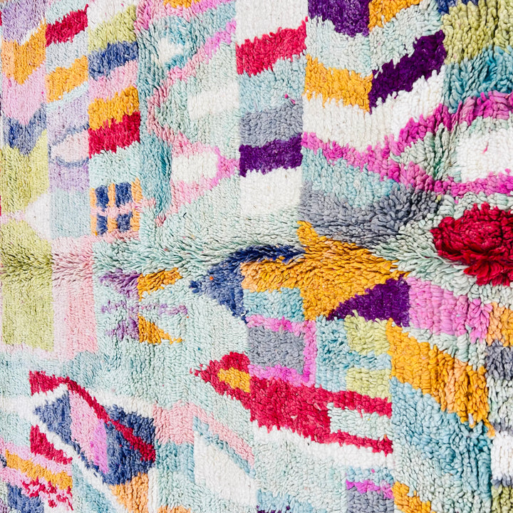 Colorful vintage Moroccan rug with vibrant geometric patterns and traditional Berber design in red, lilac, teal, yellow, and orange.