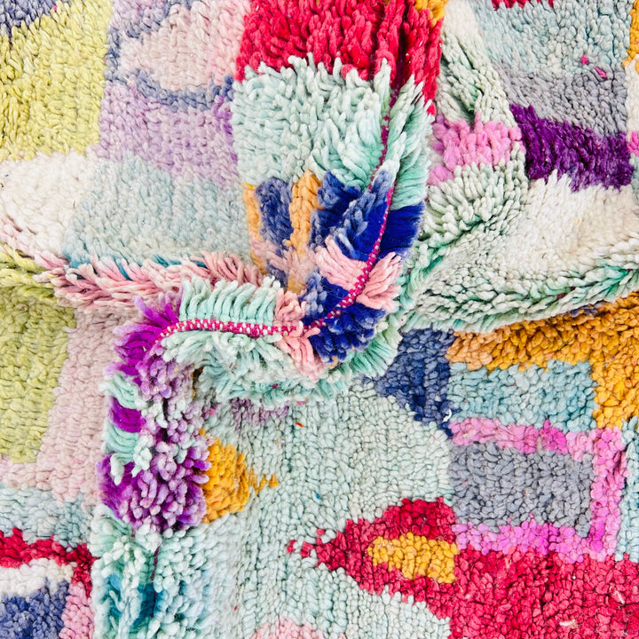Vintage colorful Moroccan wool rug with red, lilac, teal patterns, showcasing traditional Berber craftsmanship.