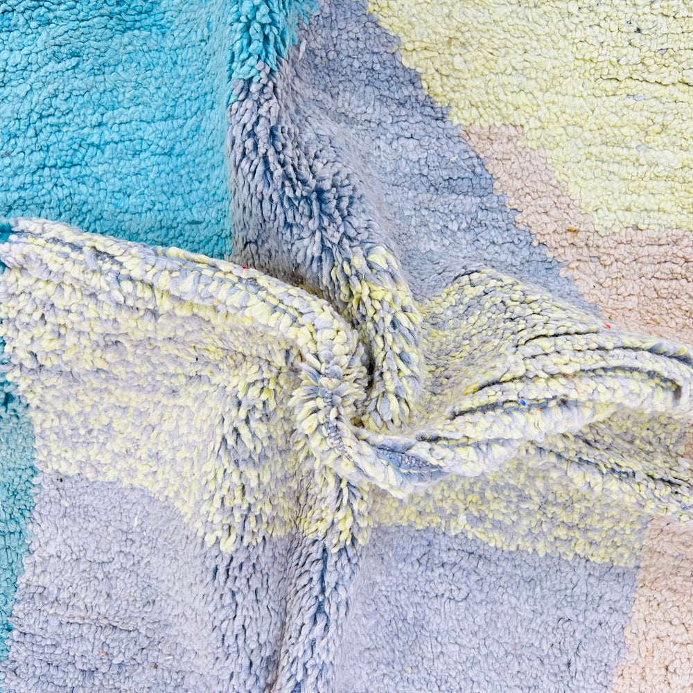 Close-up of vintage Moroccan rug with abstract geometric design in earthy tones, handmade wool from the Atlas Mountains.