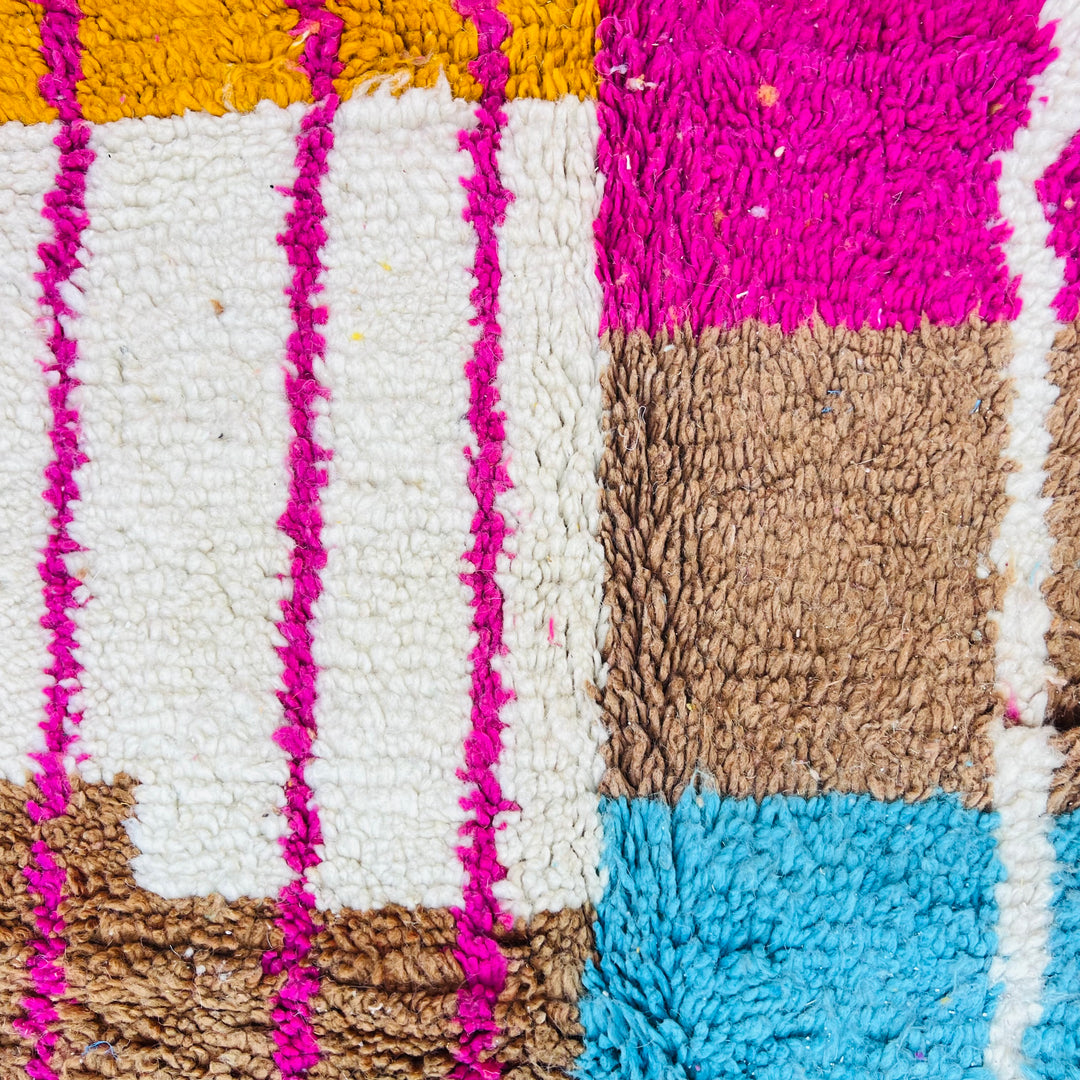 Colorful Moroccan vintage rug with geometric tribal motifs in fuchsia, brown, and turquoise. Handwoven Berber craftsmanship.