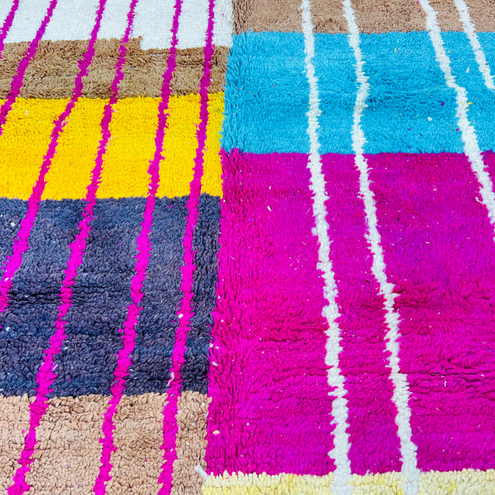 Colorful Moroccan vintage rug with vibrant fuchsia, turquoise, and earthy tones, featuring intricate geometric patterns. Moroccan rugs for sale.