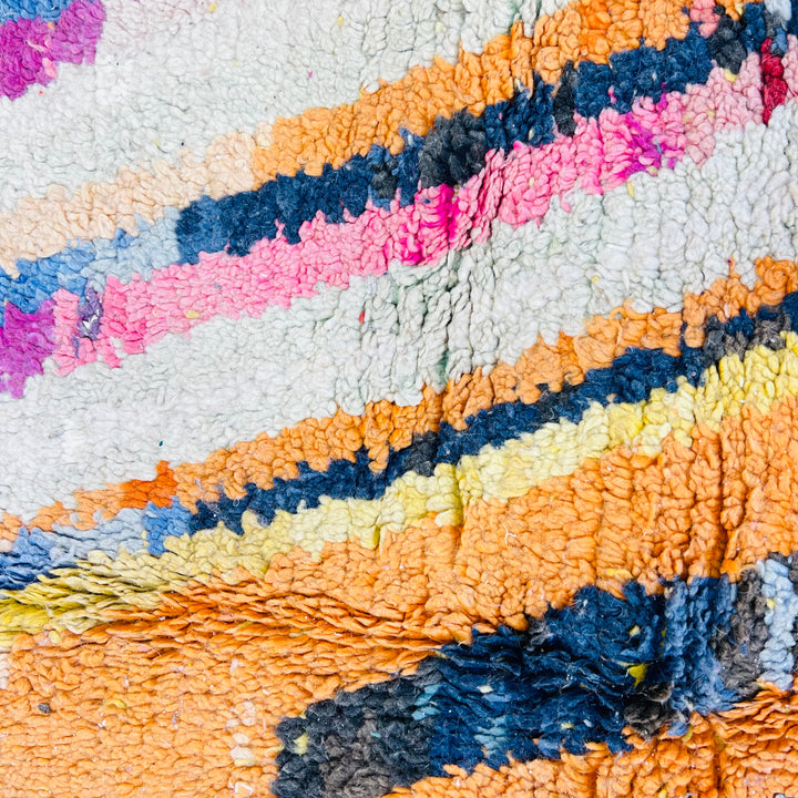 Vintage colorful Moroccan rug with geometric motifs in orange, pink, blue, and yellow. Handcrafted by Berber artisans.