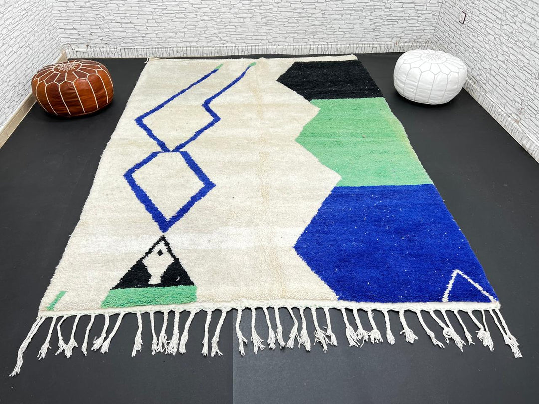 Handmade ivory Moroccan wool rug with green, blue, and black geometric abstract patterns